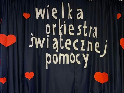 Scena w Świetlicy Kultury z napisem "Wielka Orkiestra Świątecznej Pomocy". 