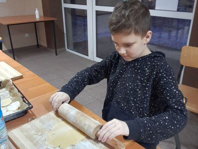 Chłopiec z Placówki Wsparcia Dziennego w Sulechowie wałkujący ciasto.