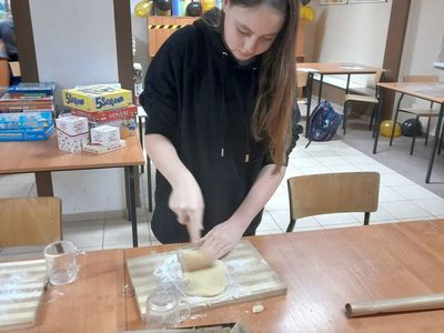 Dziewczynka z Placówki Wsparcia Dziennego w Sulechowie wałkująca ciasto.