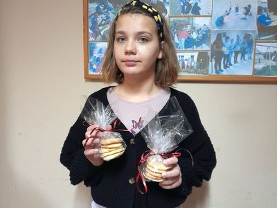 Dziewczynka z Placówki Wsparcia Dziennego w Sulechowie prezentująca przygotowane przez siebie prezenty- ciastka.