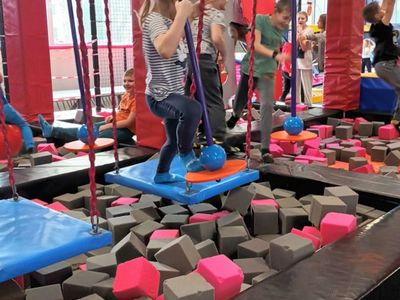 Dzieci z Ostrowca bawią się w parku trampolin, skaczą na piankowych klockach i korzystają z huśtawek. 