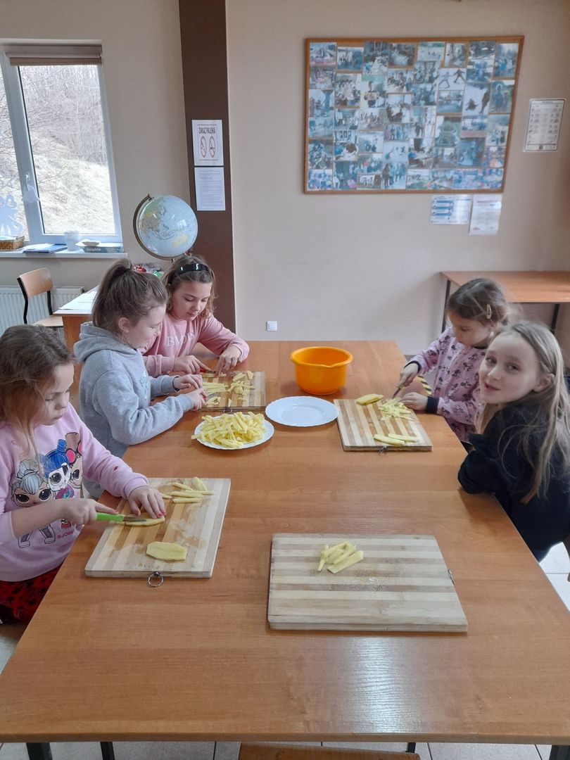 Dzieci z Placówki Wsparcia Dziennego w Sulechowie przygotowują ziemniaki, kroją je. 