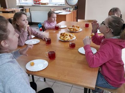 Pięć dziewczynek z Placówki Wsparcia Dziennego w Sulechowie, które spożywają deser - oponki serowe.