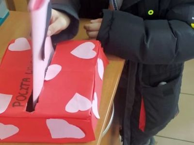 Wychowanek z Placówki Wsparcia Dziennego z Lasek wrzuca swoją laurkę do skrzynki Walentynkowej.