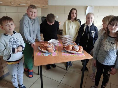 Dzieci z Placówki Wsparcia Dziennego w Kosierzewie przy stoliku ze słodkimi pączkami