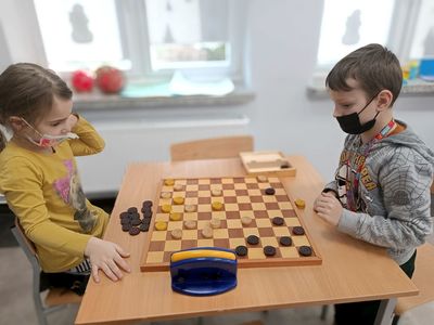Dwoje wychowanków podczas rozgrywki warcabowej w ramach zajęć w Świetlicy Kultury w Malechowie. 