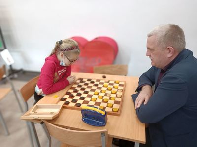 Instruktor wraz z wychowanką podczas rozgrywki warcabowej w ramach zajęć w Świetlicy Kultury w Malechowie. 
