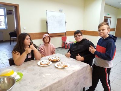 Dzieci z Karwic pozują z minipączkami przy stole, które samodzielnie wykonały.