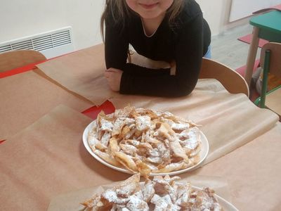 Kasia z Placówki Wsparcia Dziennego w Niemicy prezentuje gotowe do zjedzenia chrusty.