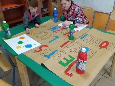 2.Dzieci z Placówki Wsparcia Dziennego z Lasek wykonują plakat kolorowymi farbami. 3.Napis wykonany przez dzieci z Placówki Wsparcia Dziennego z Lasek.