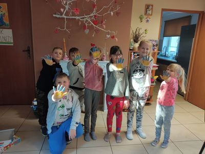 Dzieci z Placówki Wsparcia Dziennego w Kosierzewie pokazują rączki wymalowane w kolorach flagi Ukrainy.