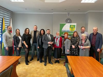 Przedstawiciele stowarzyszeń, pracownicy Urzędu wraz z wójtem Radosław Nowakowskim pozują do zdjęcia po podpisaniu umów na realizację zadań publicznych.