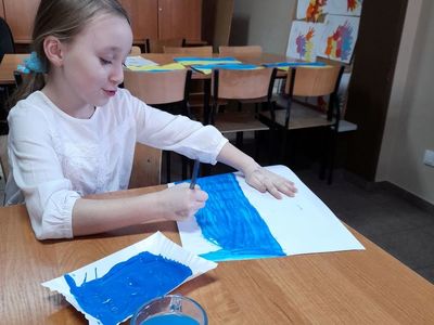 Dziewczynka z PWD w Sulechowie podczas malowania farbami flagi Ukrainy. 