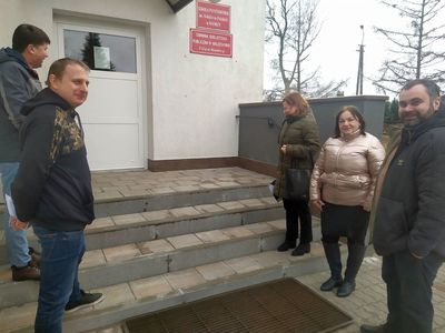Wójt Radosław Nowakowski z dyrektor Iwoną Nowak - Gancarz i pracownikami urzędu oraz wykonawcą przed szkołą.