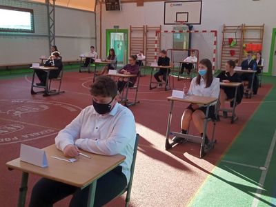 Ósmoklasiści ze Szkoły Podstawowej w Lejkowie podczas pisania egzaminu w sali gimnastycznej.