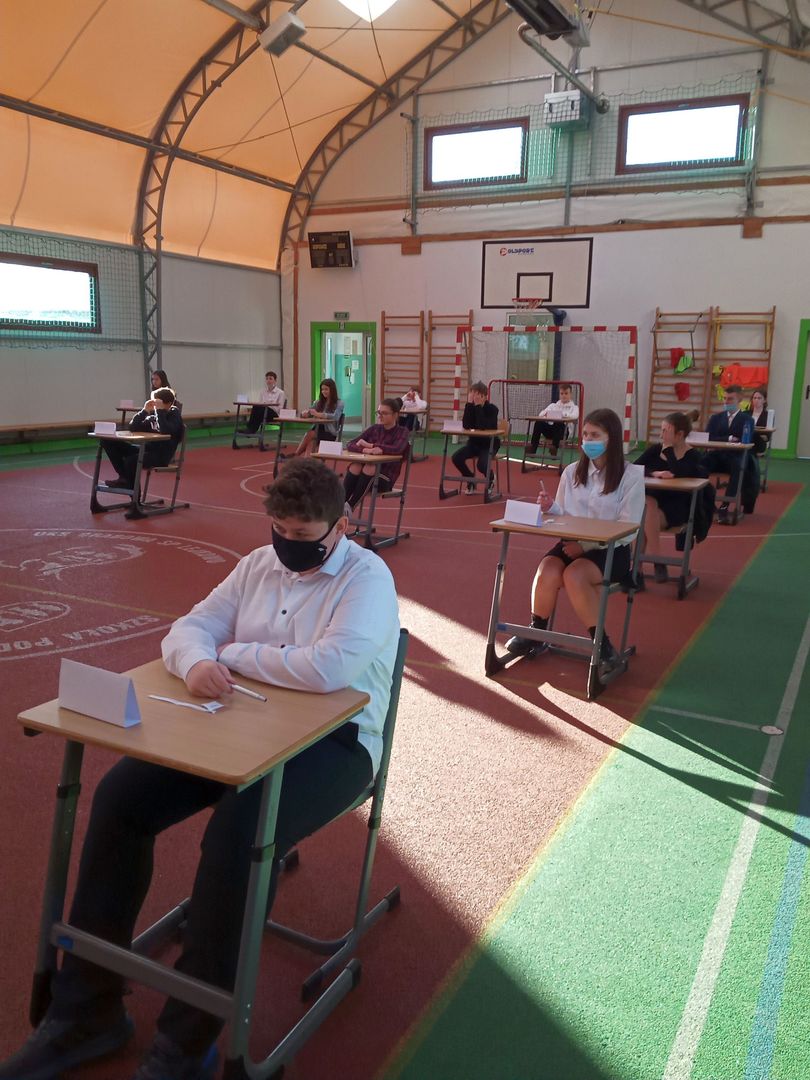 Ósmoklasiści ze Szkoły Podstawowej w Lejkowie podczas pisania egzaminu w sali gimnastycznej. 