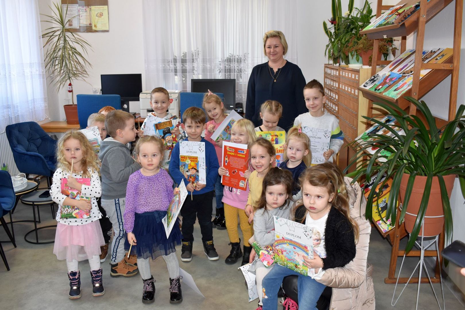 Uczestnicy konkursu plastycznego "Mój Kotek" z nagrodami, dyplomami oraz dyrektor Anną Zając.