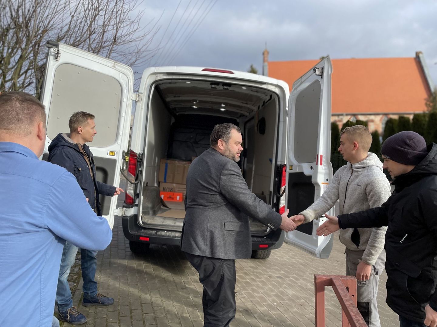Wójt Radosław Nowakowski przed budynkiem Urzędu Gminy Malechowo wita się z kierowcami, którzy zawiozą zebrane produkty na granicę polsko - ukraińską.