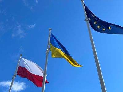 Flagi Polski, Ukrainy oraz Unii Europejskiej powiewające na niebie. 
