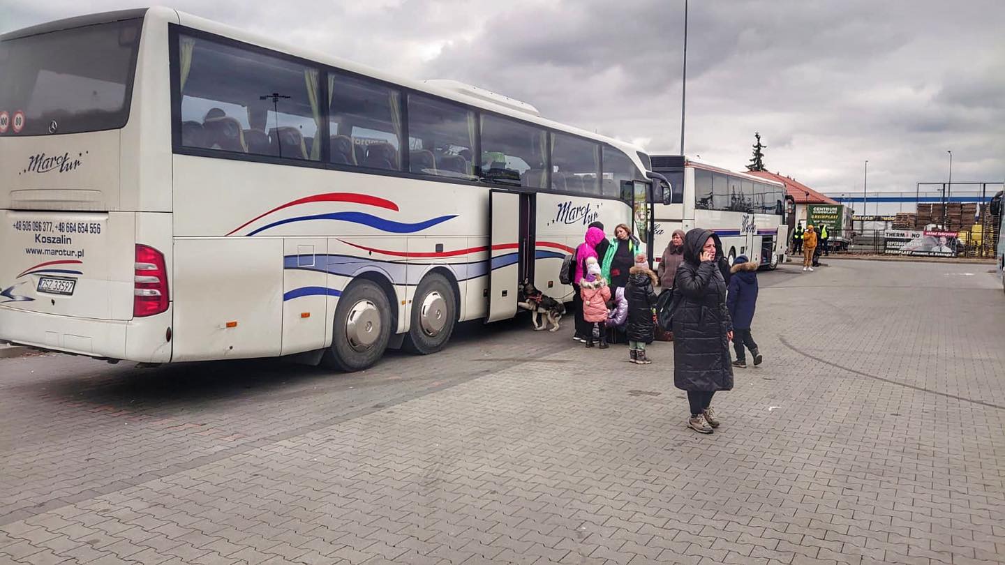 Osoby, które podróżowały z Ukrainy na parkingu przed autokarem.