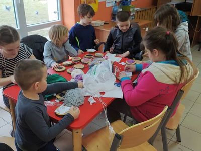 Dzieci z Placówki Wsparcia Dziennego z Lasek wykonują obrazy 3D z gwoździ i włóczki na drewnie.