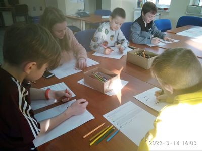 Dzieci z Placówki Wsparcia Dziennego w Pękaninie odkodowują wiosenne obrazki.