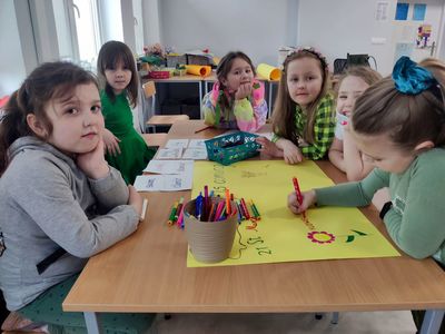 Dzieci z młodszej grupy przygotowują plakat na temat wiosny w języku angielskim.