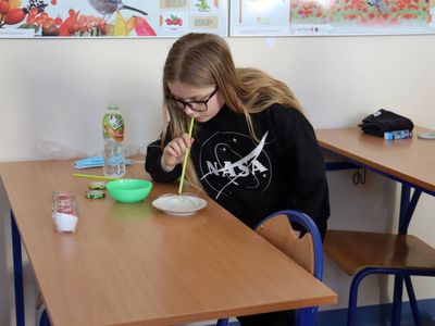 Uczennica klasy piątej ze Szkoły Podstawowej w Niemicy w trakcie wykonywania eksperymentu z wodą