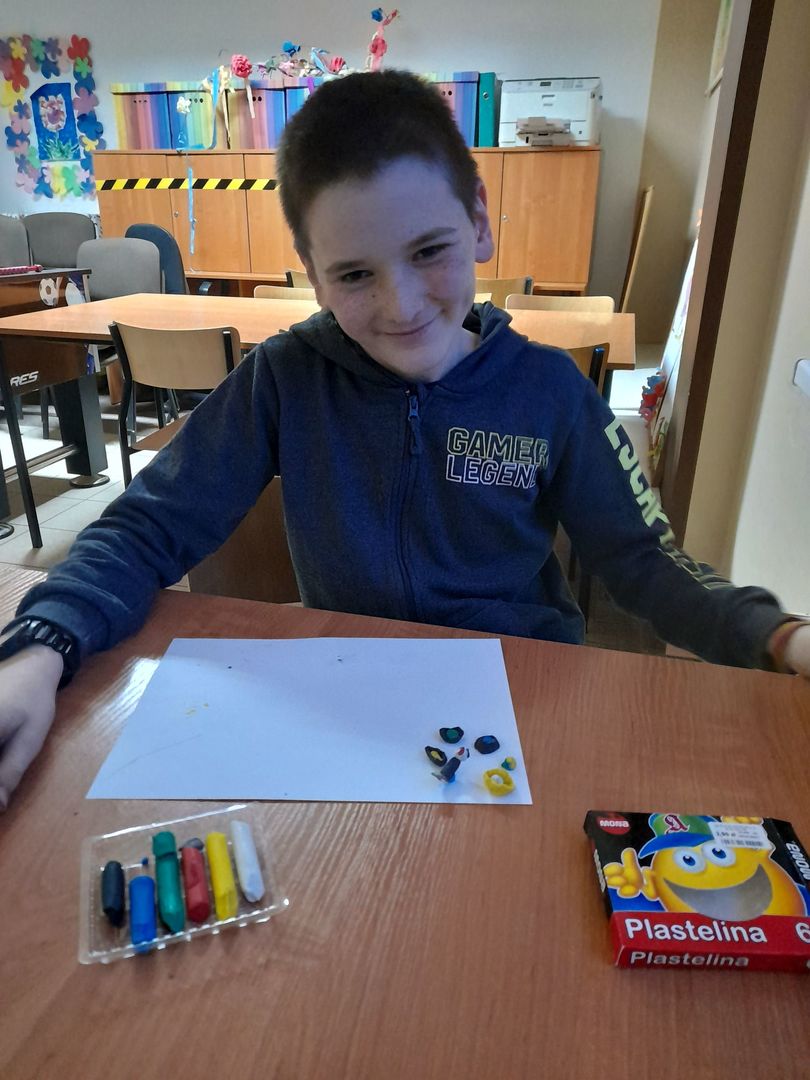 Chłopiec z Placówki Wsparcia Dziennego w Sulechowie lepiący figurki z plasteliny.
