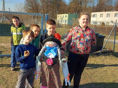 Wychowankowie z Placówki Wsparcia Dziennego z Lasek prezentują wykonaną marzannę. 