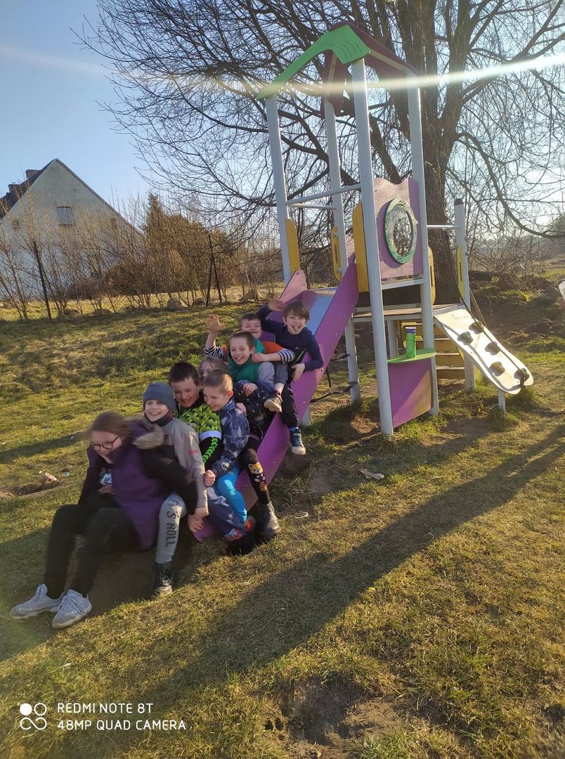 Wychowankowie z Placówki Wsparcia Dziennego z Lasek wraz z wychowawczyniami i rodzicami przy ognisku.
