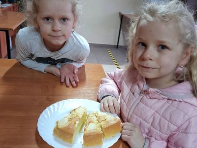 Dwie dziewczynki z Placówki Wsparcia Dziennego w Sulechowie pozujące do zdjęcia z przygotowanym przez siebie ciastem.