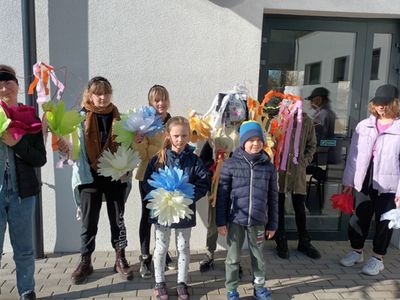 Dzieci z Placówki Wsparcia Dziennego w Malechowie przed budynkiem świetlicy pozują z wykonanymi kukłami.