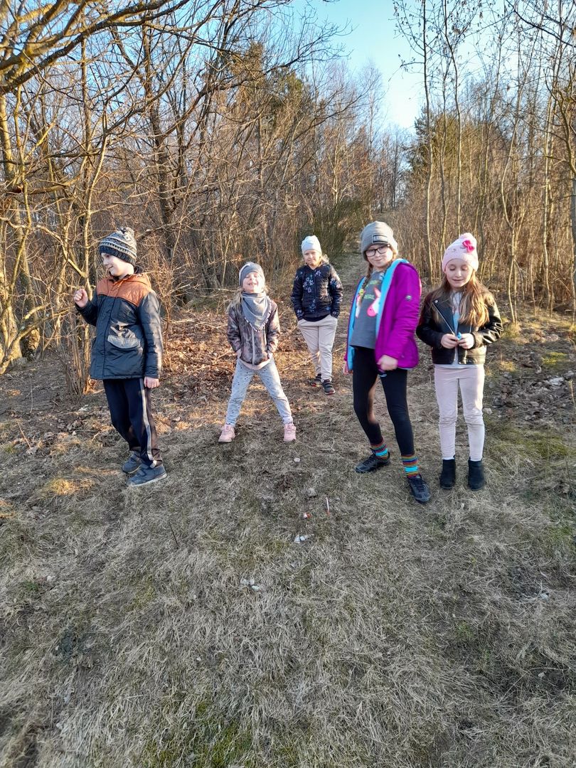 Cztery dziewczynki i chłopiec z Placówki Wsparcia Dziennego w Sulechowie podczas spaceru w lesie.