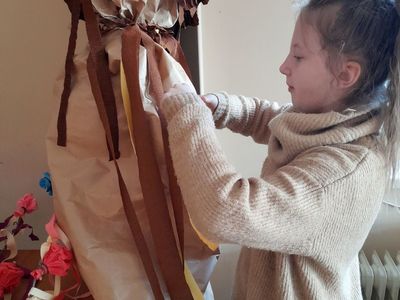 Dziewczynka z PWD w Sulechowie dekorująca Marzannę kawałkami krepiny.