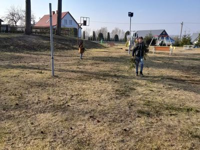 Dwaj chłopcy zbierający gałęzie na placu zabaw przy PWD w Sulechowie.
