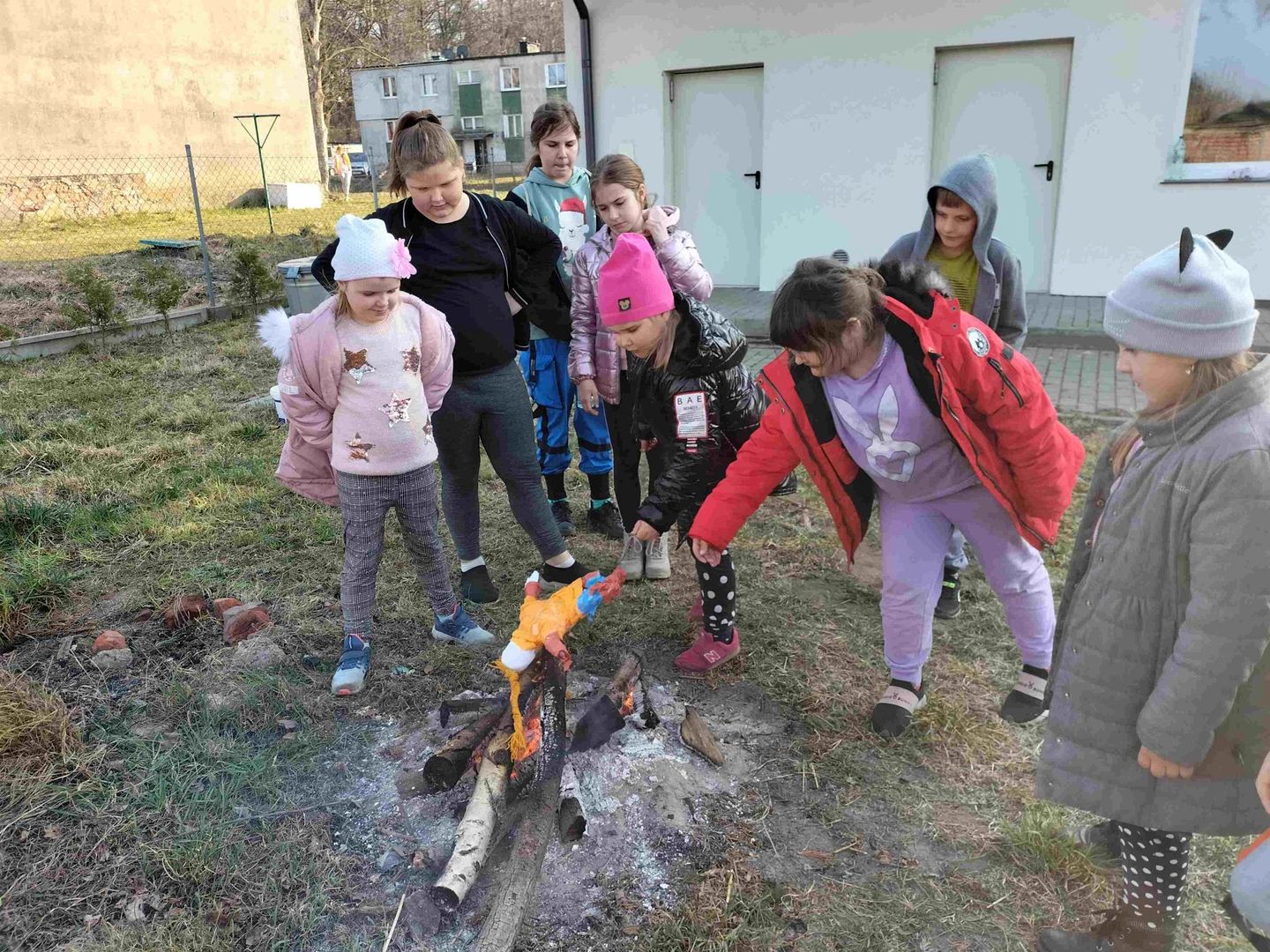 Dzieci z Kusic palą marzannę przy ognisku.