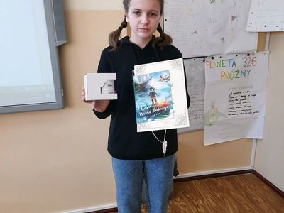 Finalistka konkursu kaligraficznego prezentuje dyplom oraz nagrodę.