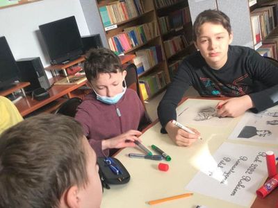 Lekcja biblioteczna, dwaj chłopcy przy pracach. 