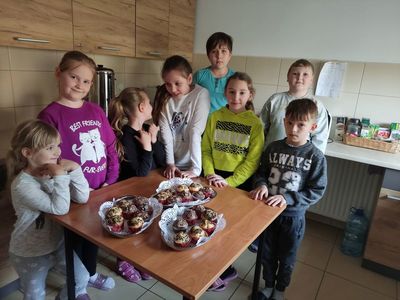 Grupa dzieci z PWD w Kosierzewie przy stoliku z upieczonymi muffinami.