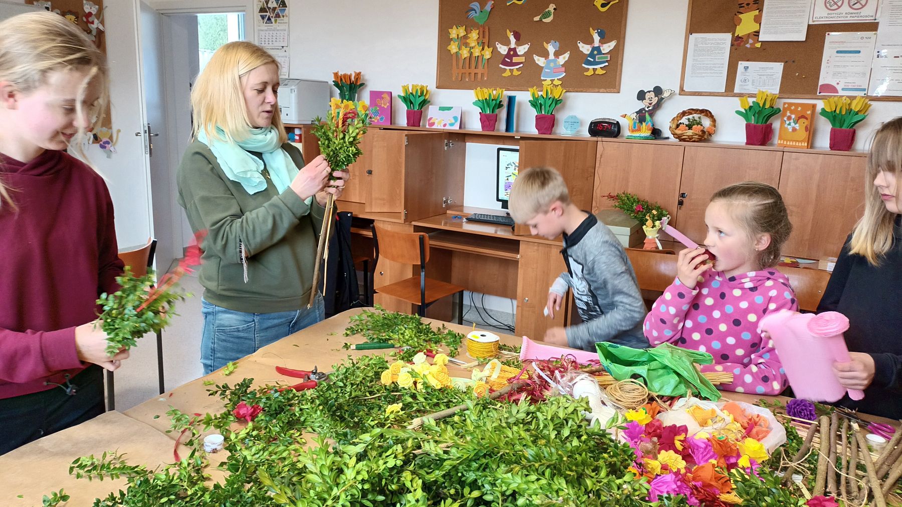 Troje dzieci i mama przygotowują palmy w domu wiejskim w Ostrowcu. 