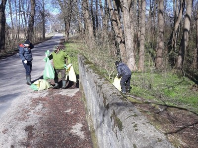 Trzech mężczyzn z workami pełnymi śmieci.