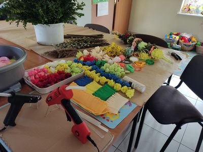 Stolik w Placówki Wsparcia Dziennego w Kosierzewie z przygotowanymi materiałami do robienia palm.
