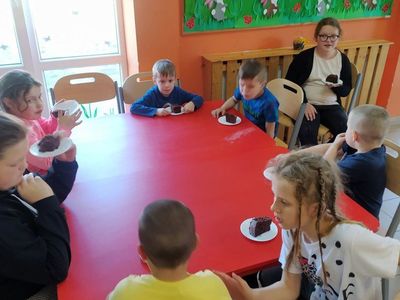 Dzieci z Placówki Wsparcia Dziennego w Laskach degustują upieczone ciasto czekoladowe. 