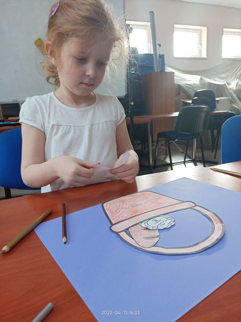 Dziewczynka z Placówki Wsparcia Dziennego w Pękaninie tworzy plakat ilustrujący święconkę.