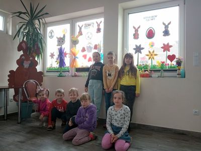 Dzieci z Placówki Wsparcia Dziennego w Niemicy przy udekorowanych oknach.