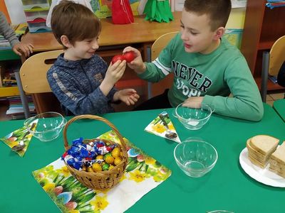 Wychowankowie z Placówki Wsparcia Dziennego w Laskach stukają się pisankami.