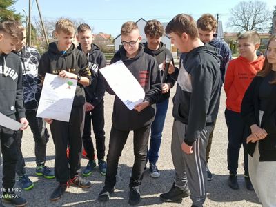 Grupa uczniów Zespołu Szkół w Ostrowcu podczas obchodów Dnia Ziemi na placu przed szkołą.