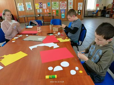 Dzieci z Placówki Wsparcia Dziennego w Pękaninie tworzą Orła białego z kółek origami. 
