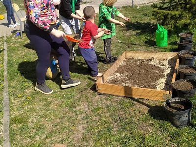 Dzieci z Placówki Wsparcia Dziennego z Lasek przygotowują podłoże do warzywniaka.
